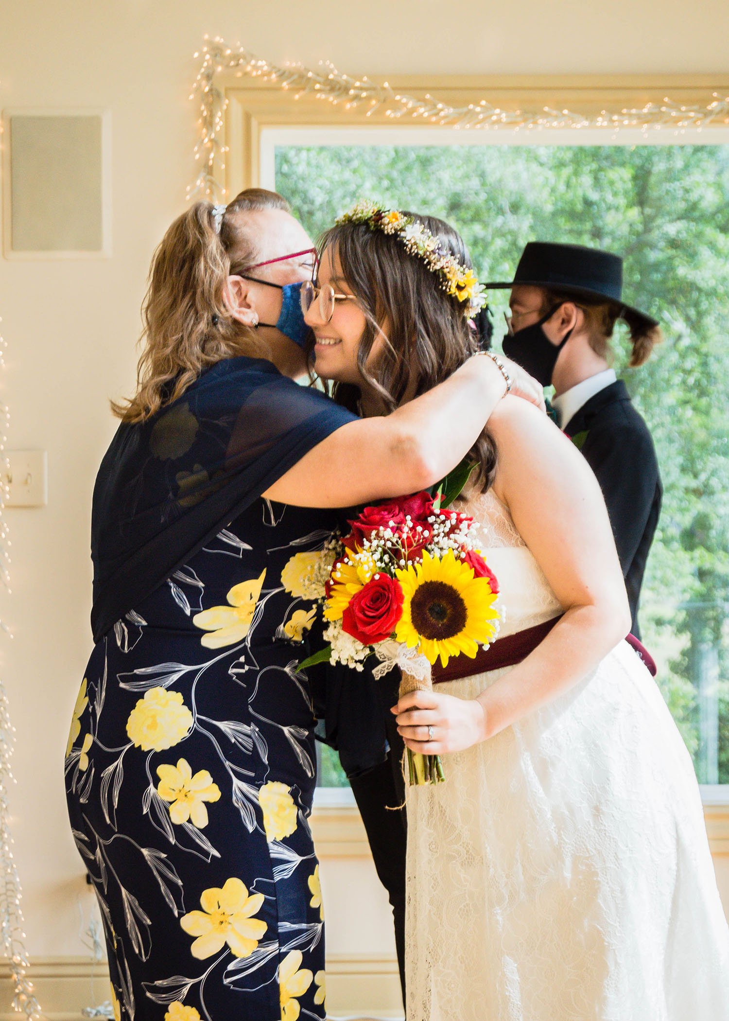 The mother of the bride wraps her arms around her daughter for a quick hug before the wedding ceremony begins.