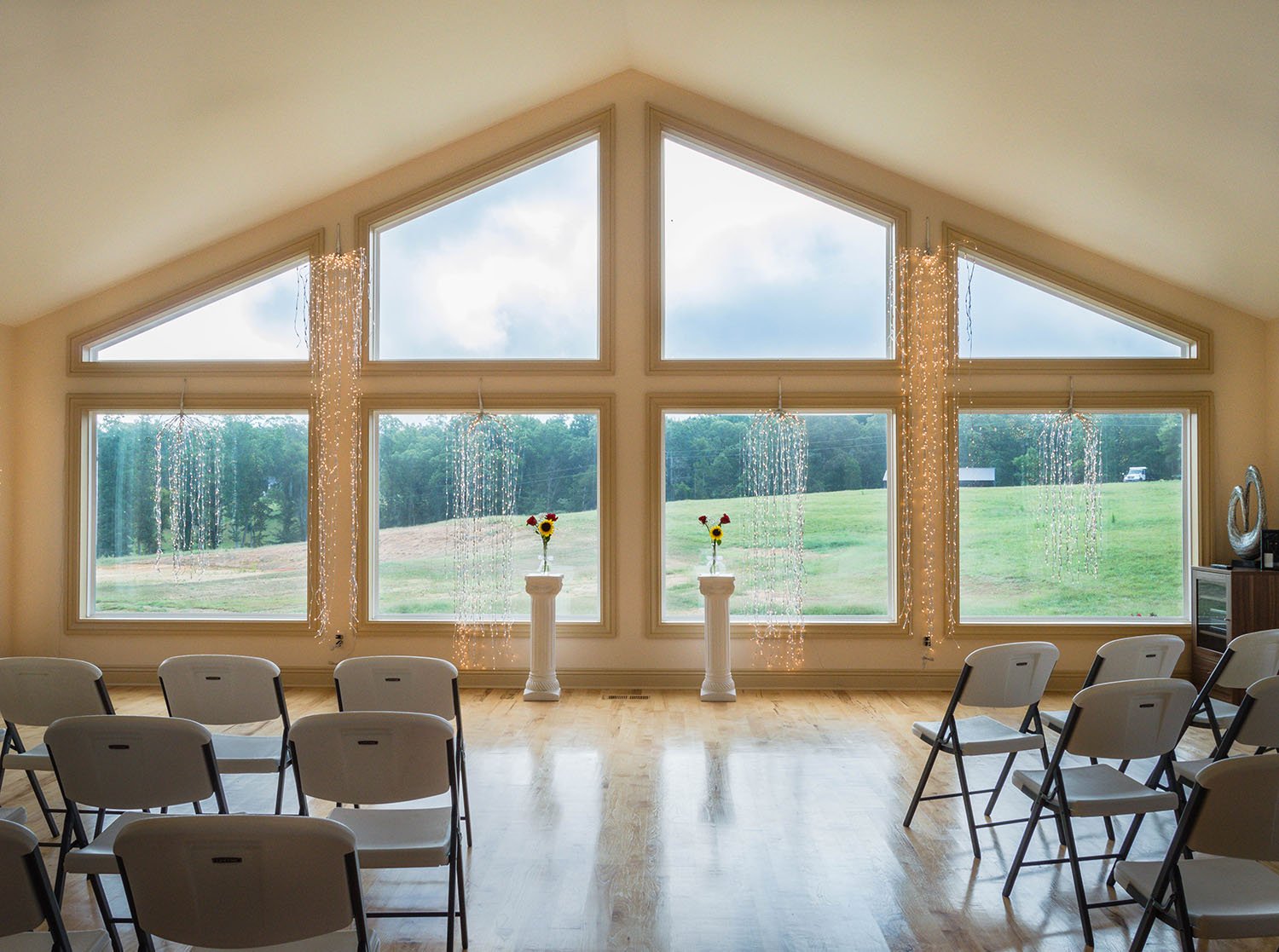 The front of the Davidson Farm venue which features a wall of windows that looks out to the hilly property and sky.