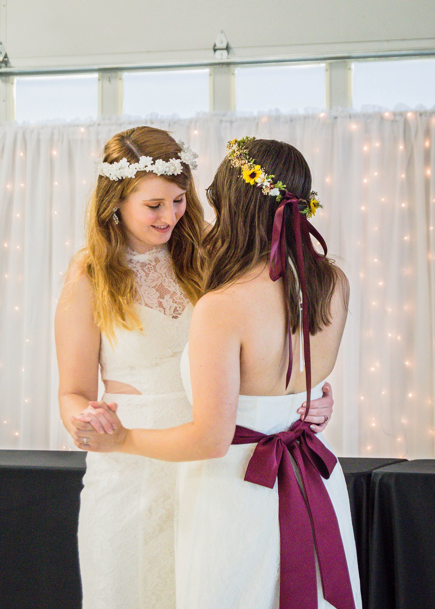 A newlywed LGBTQ+ couple has their first dance during their reception.