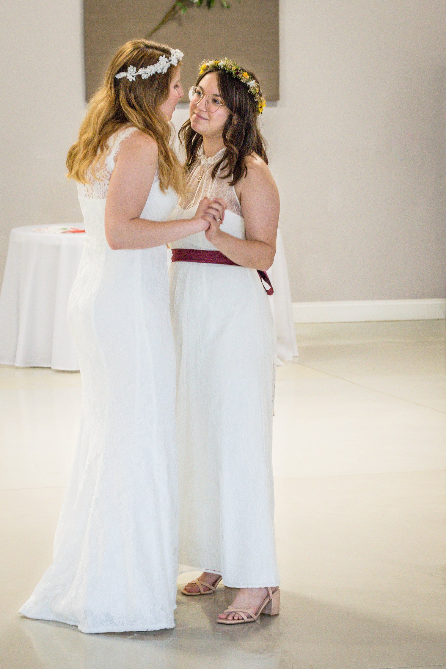 Two LGBTQ+ brides have their first dance during their reception.