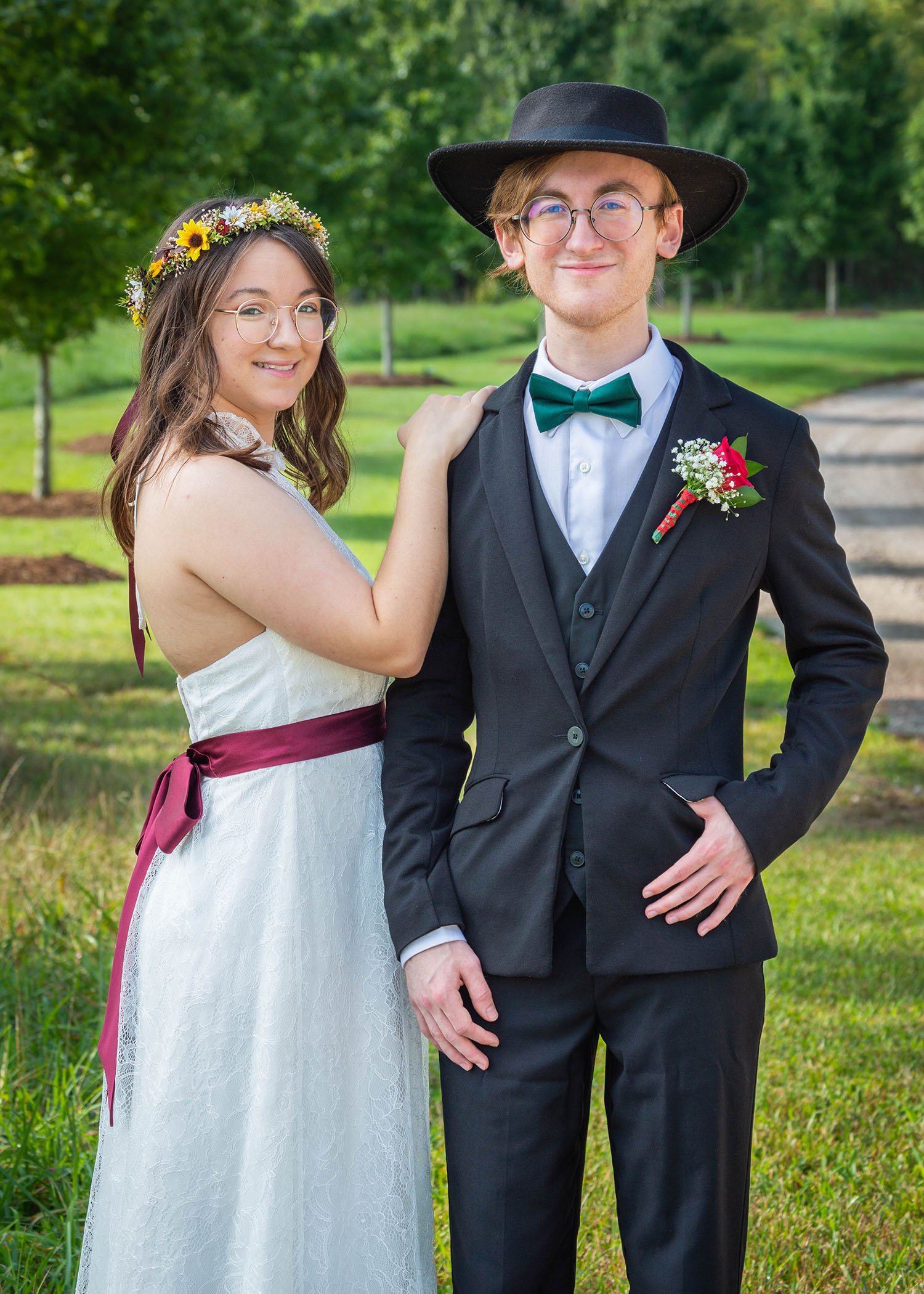 An LGBTQ bride stands next to her queer sibling for a photo on the property of Davidson Farm, a wedding venue in South Carolina.