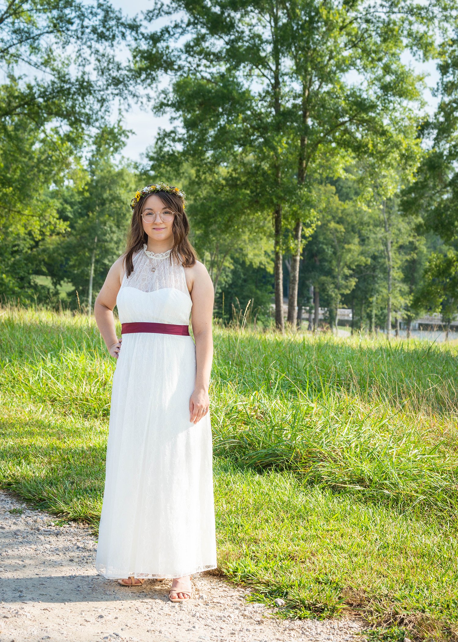 A queer bride stands outside the wedding venue at Davidson Farm for portraits in her dress and flower crown.