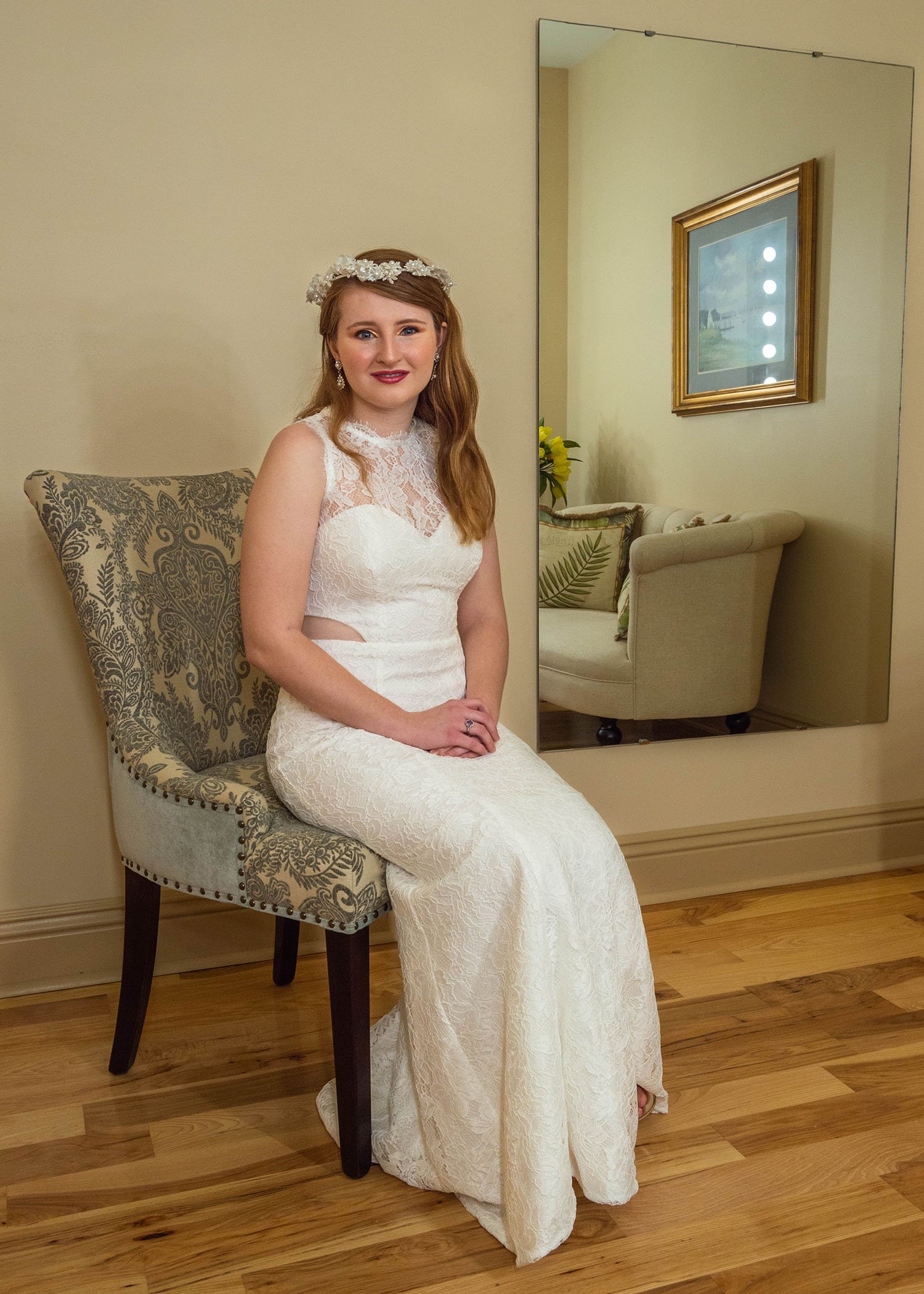 An LGBTQ+ bride sits in a chair inside of the getting ready suite at Davidson Farm for a formal portrait.