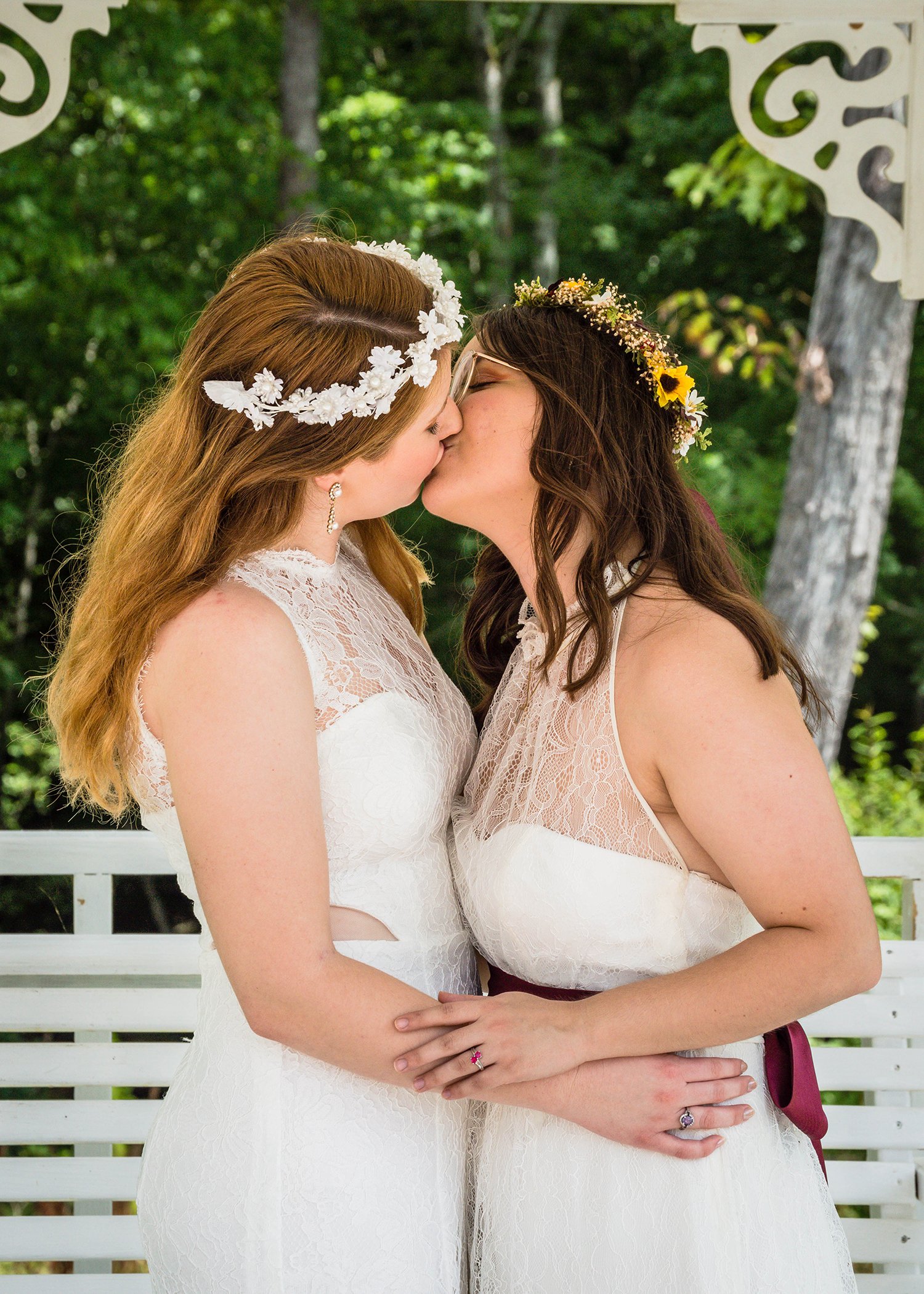 Two LGBTQ+ brides sneak in another kiss.