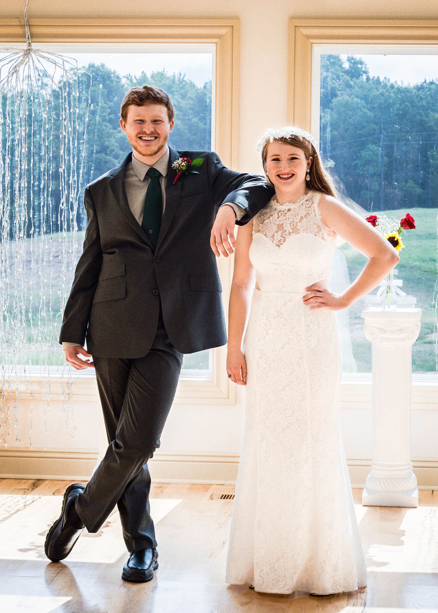 An LGBTQ marrier stands inside the wedding venue at Davidson Farm for a photo with their brother.