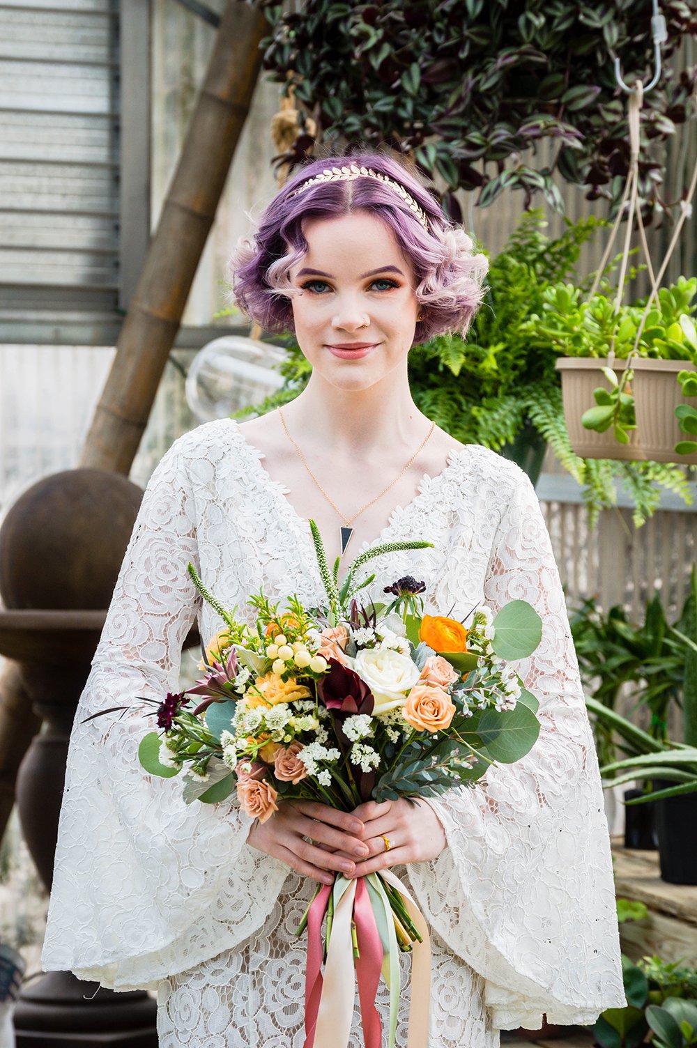 An lgbtq+ newlywed spouse holds their bouquet and smiles for a photo.