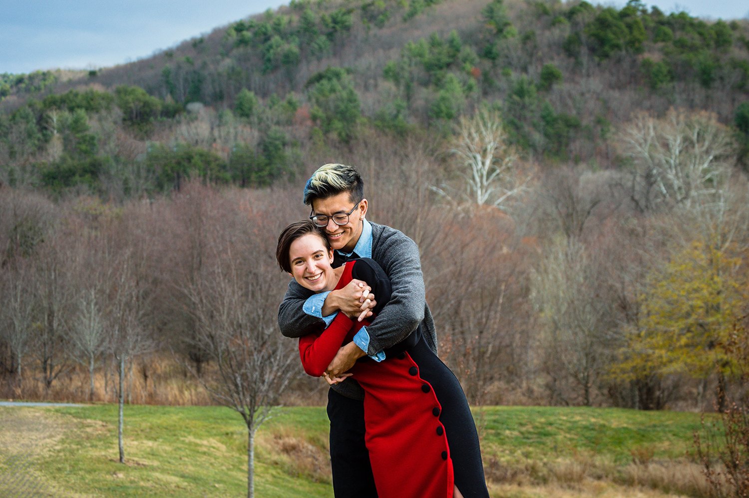 A couple embraces and smiles at the camera during an adventure couple's session in Roanoke, Virginia at the South County Public Library.