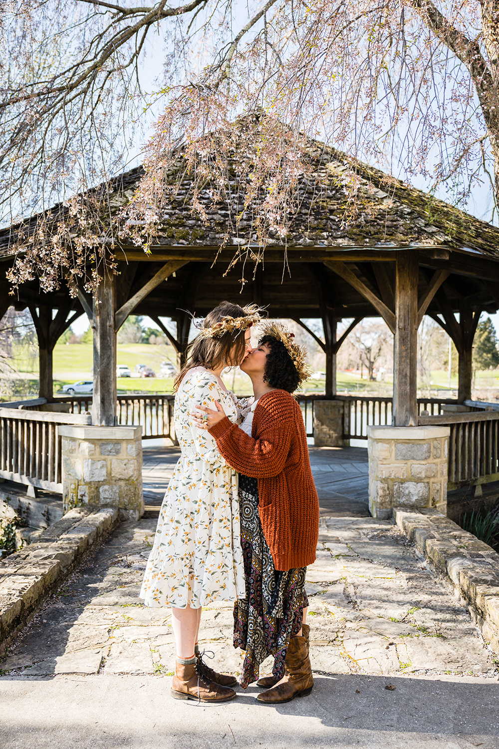 An LGBTQ+ couple on their elopement day embraces and has their first kiss in front of the gazebo at Duck Pond in Blacksburg, Virginia.