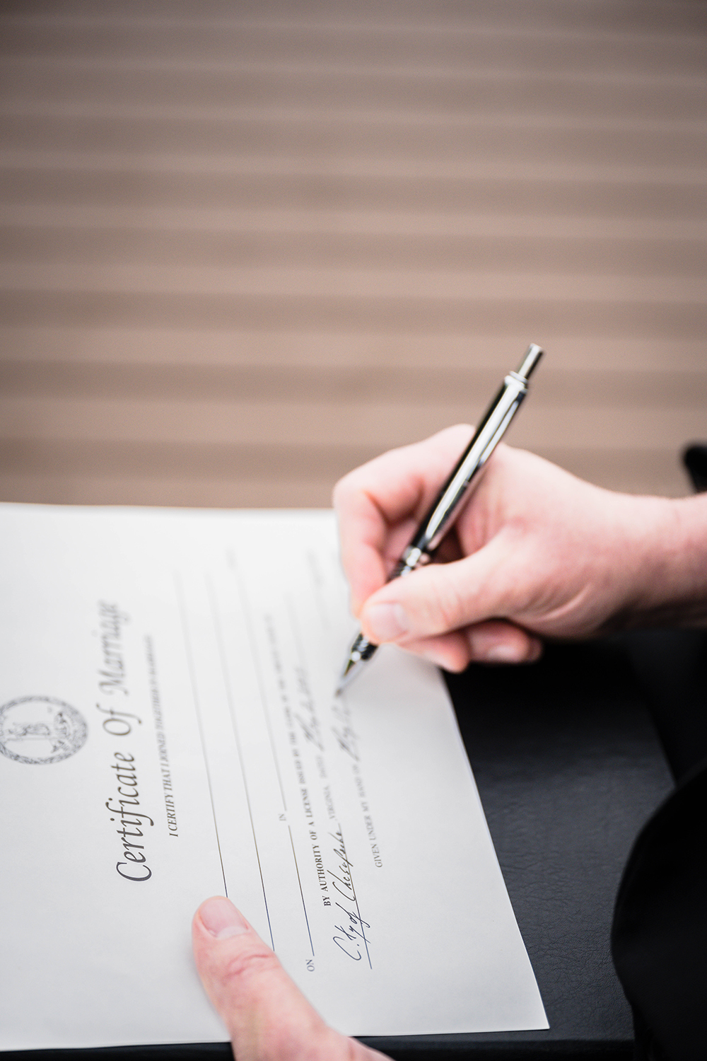 An LGBTQ+ friendly and affirming officiant fills out a marriage certificate.