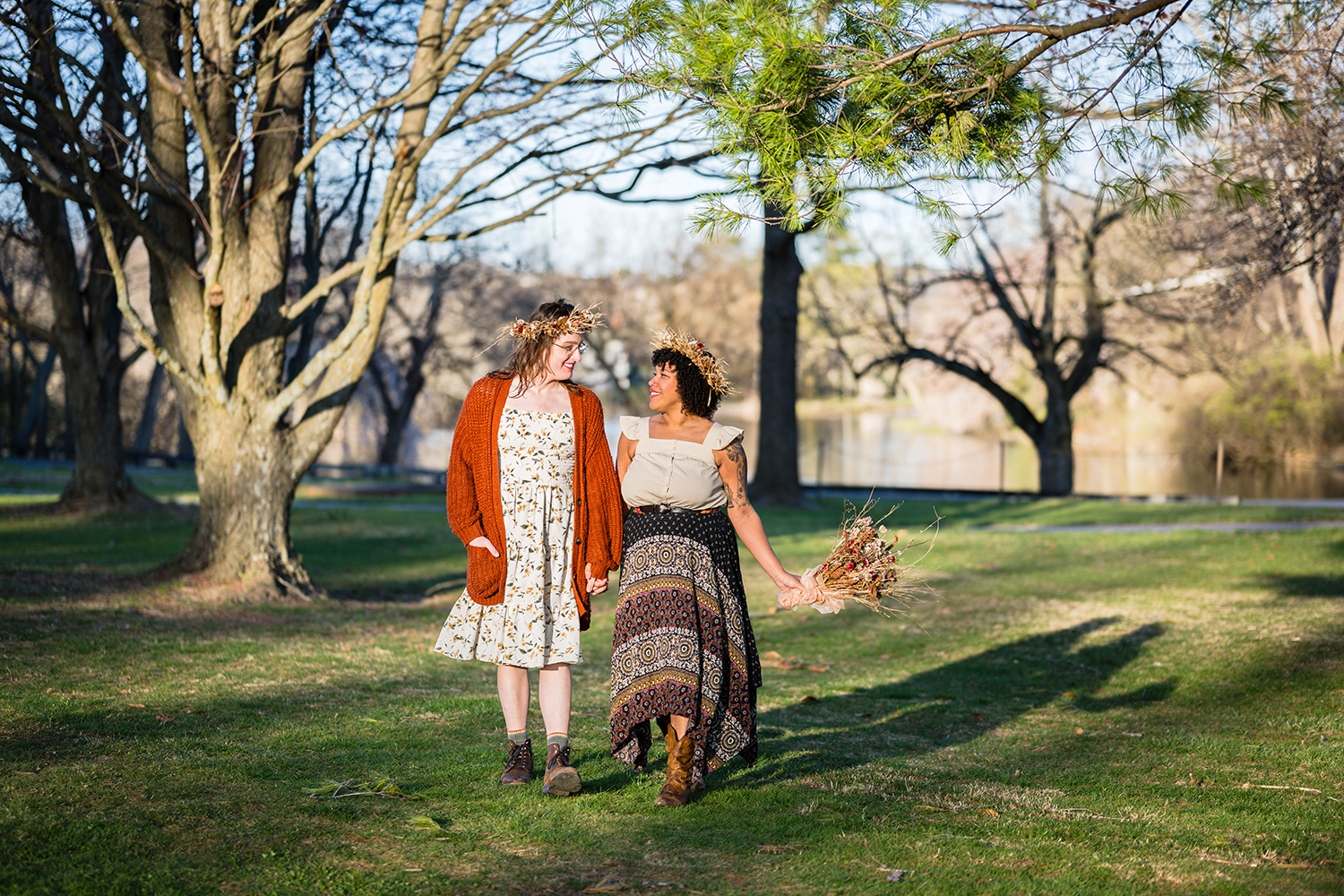 An LGBTQ+ couple walks hand-in-hand during golden hour on their elopement day.