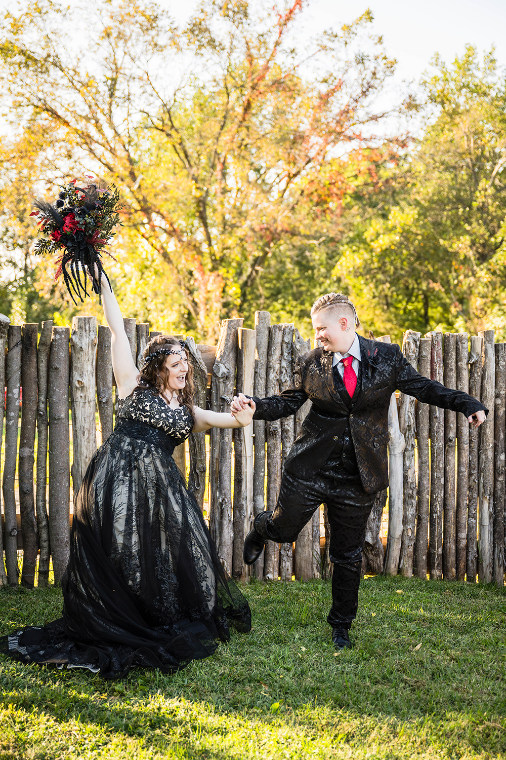 A queer couple look at one another and lift their arms up in celebration after their ceremony in the backyard of a Roanoke Airbnb on their elopement day.