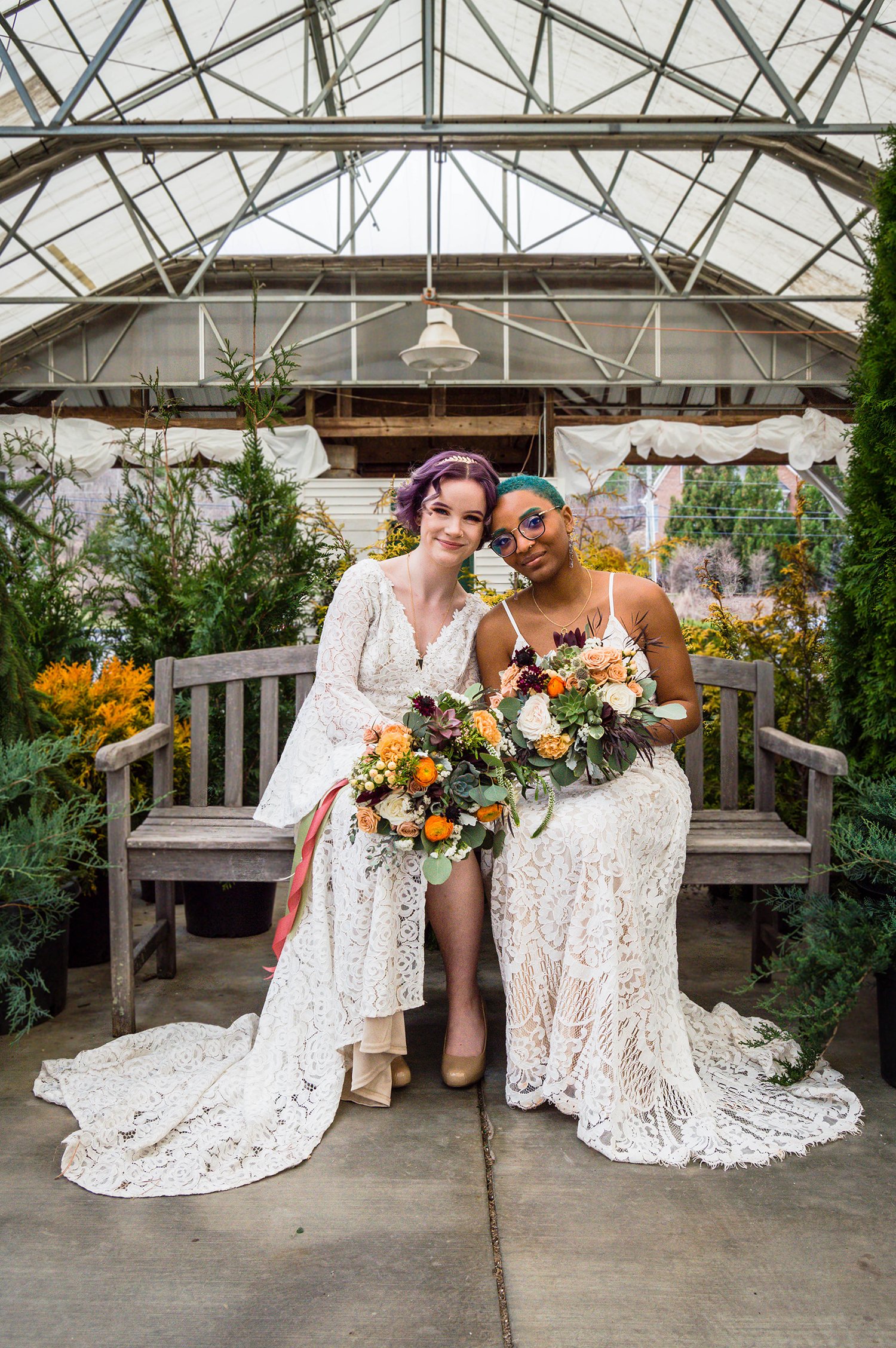 Models pose on a bench at a greenhouse elopement styled photoshoot in Virginia.