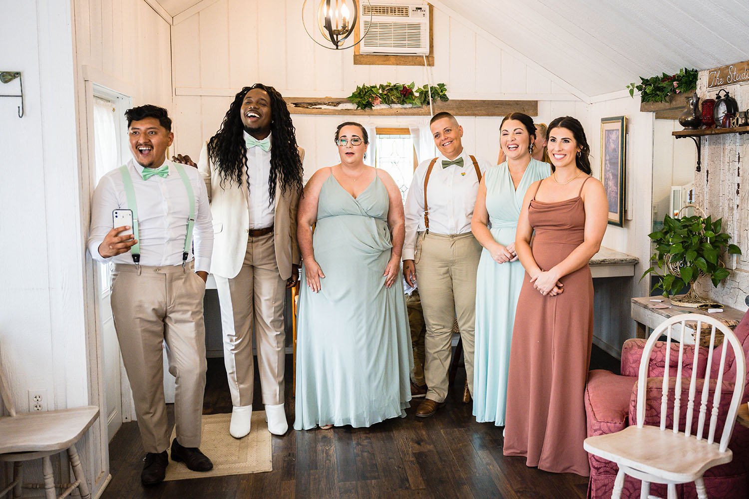 A wedding party reacts to a marrier revealing their dress and final look to them during a wedding.