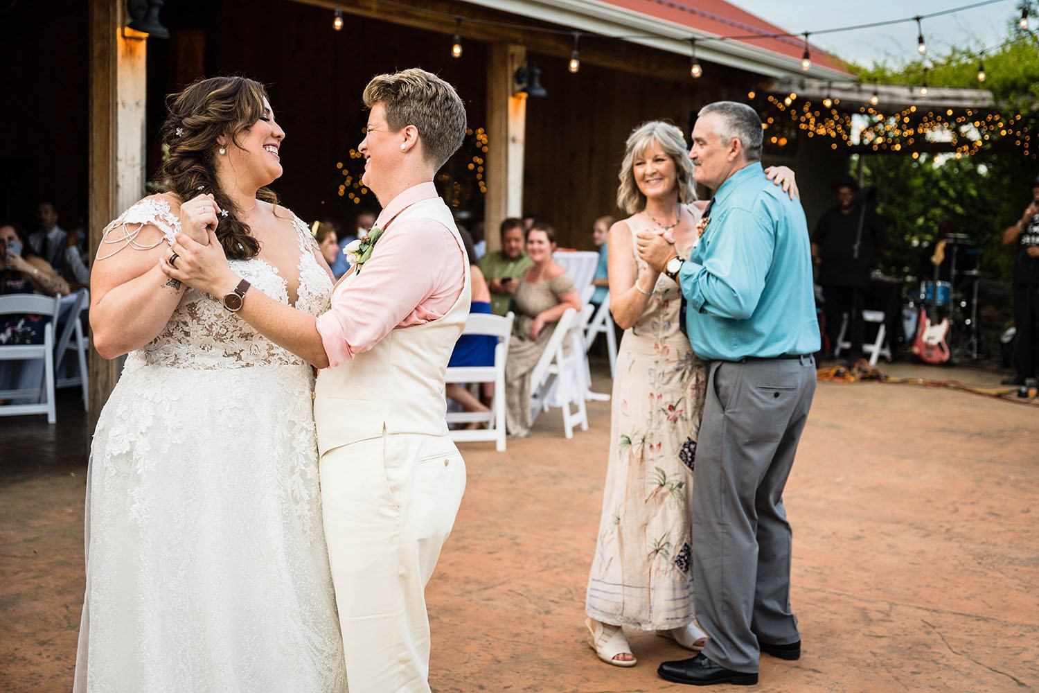 An lgbtq+ newlywed couple take to the dance floor for their first dance at the Pavilion at Black Water Junction alongside the parents of one of the marriers.