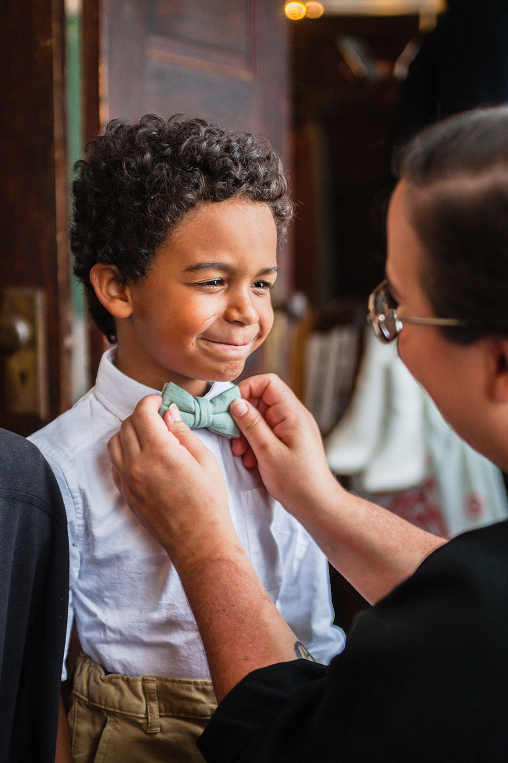 A mom fixes her son's bow tie in the bridal suite.