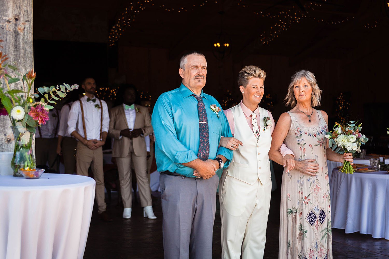 Parents of a marrier interlink arms with their child as they proceed to walk down the aisle for a wedding ceremony at the Pavilion at Black Water Junction.