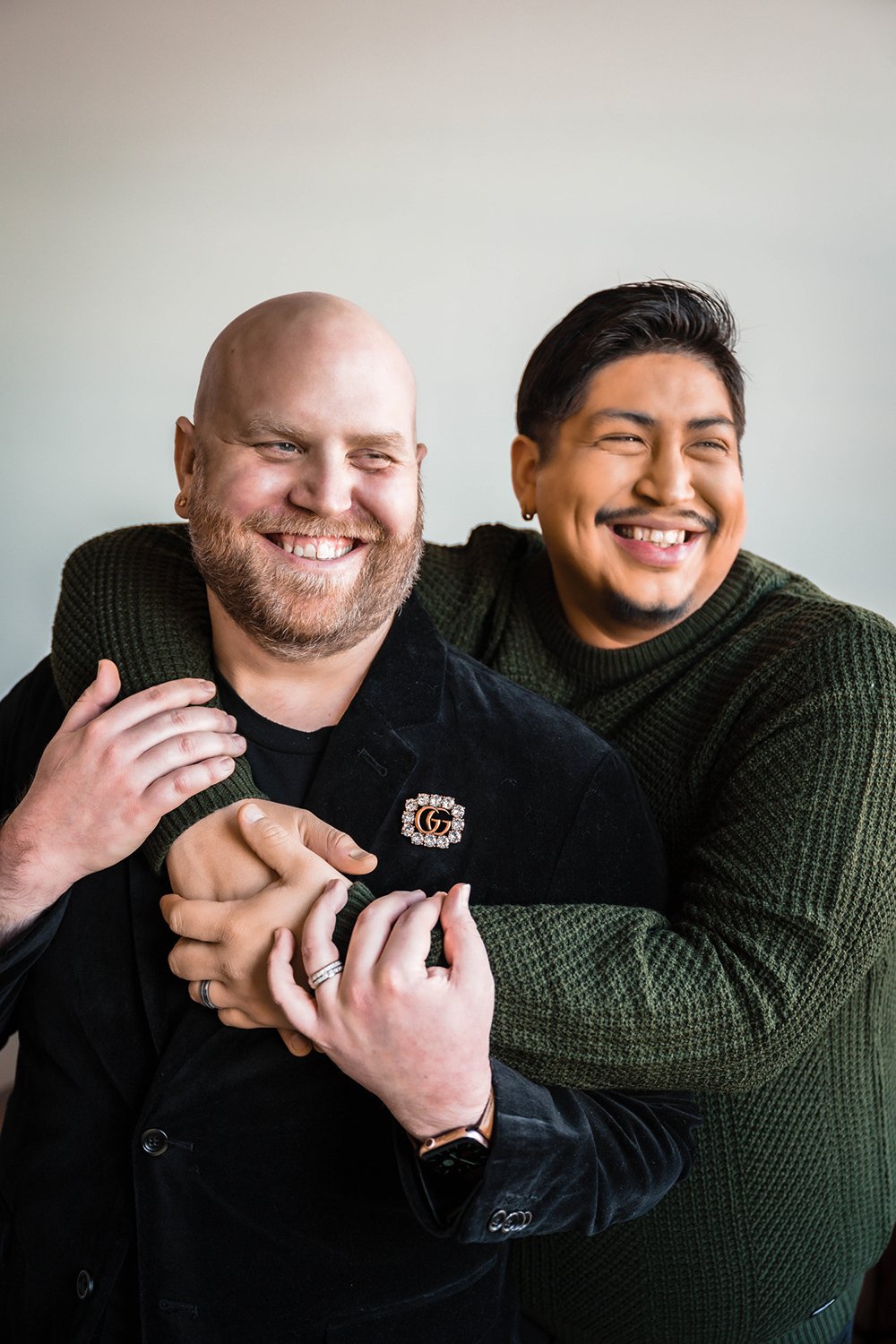 An lgbtq+ couple embraces one another and stare out the window during their at-home photoshoot in Downtown Roanoke.