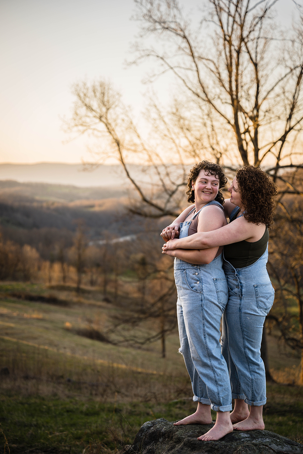 An LGBTQ+ couple hugs and looks at one another during their anniversary portrait adventure session outside of Blacksburg, Virginia.