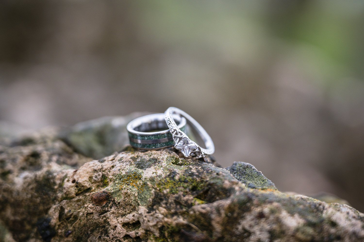 A pair of engagement rings sit atop a rock for a couple's engagement session at Mill Mountain in Virginia.