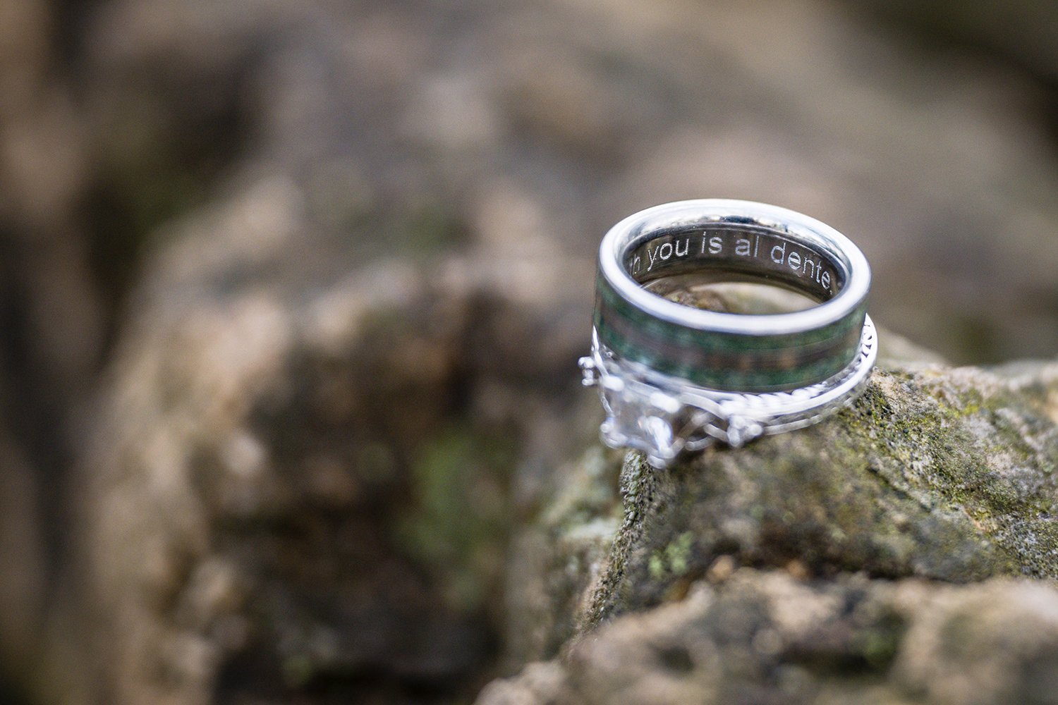 A pair of engagement rings sit atop a rock for a couple's engagement session at Mill Mountain in Virginia.