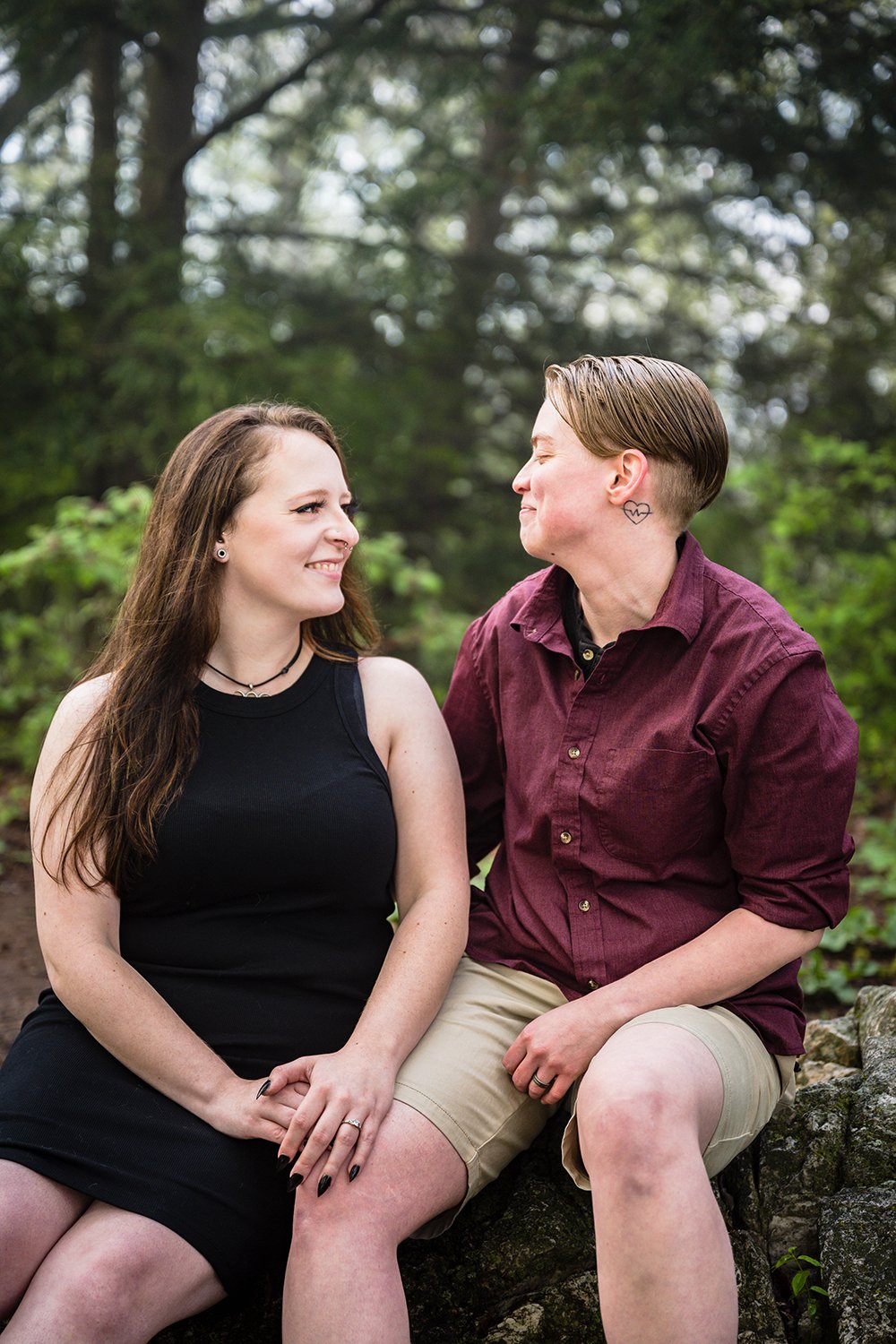 An lgbtq+ couple look at one another adoringly during their Roanoke Star engagement session at Mill Mountain.