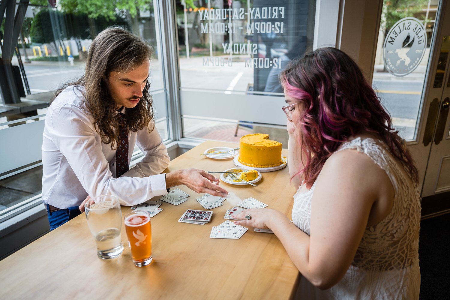 A bride and groom play a game of gin rummy in Olde Salem Brewing Company after their elopement ceremony.
