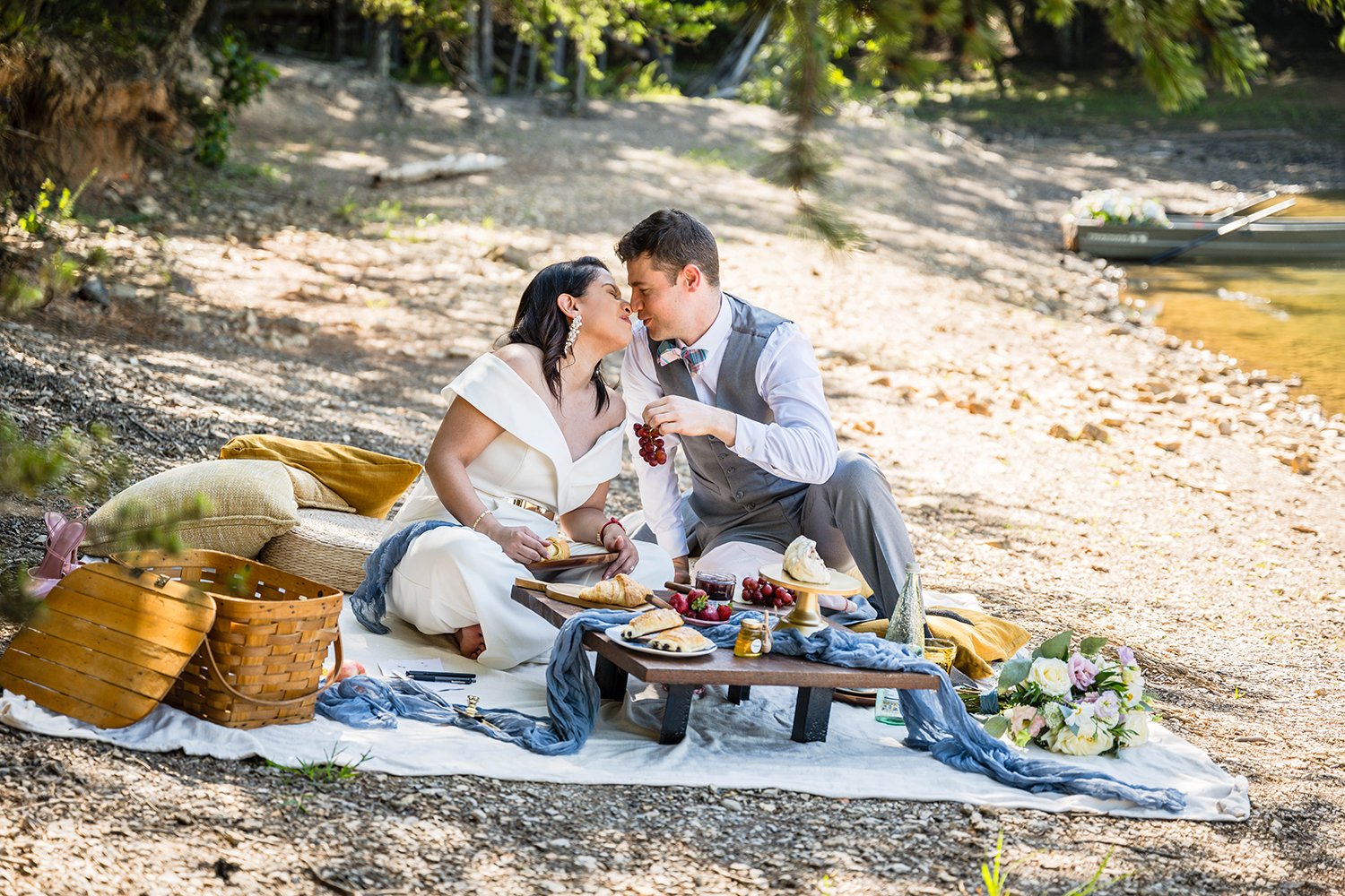 A couple sits along the shore of Carvin’s Cove having a brunch picnic during their elopement.