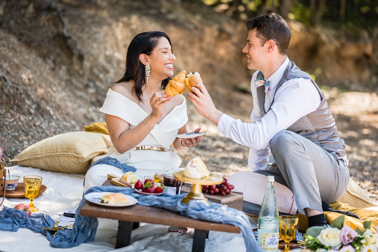 A wedding couple sits along the shore of Carvin’s Cove having a brunch picnic during their elopement.