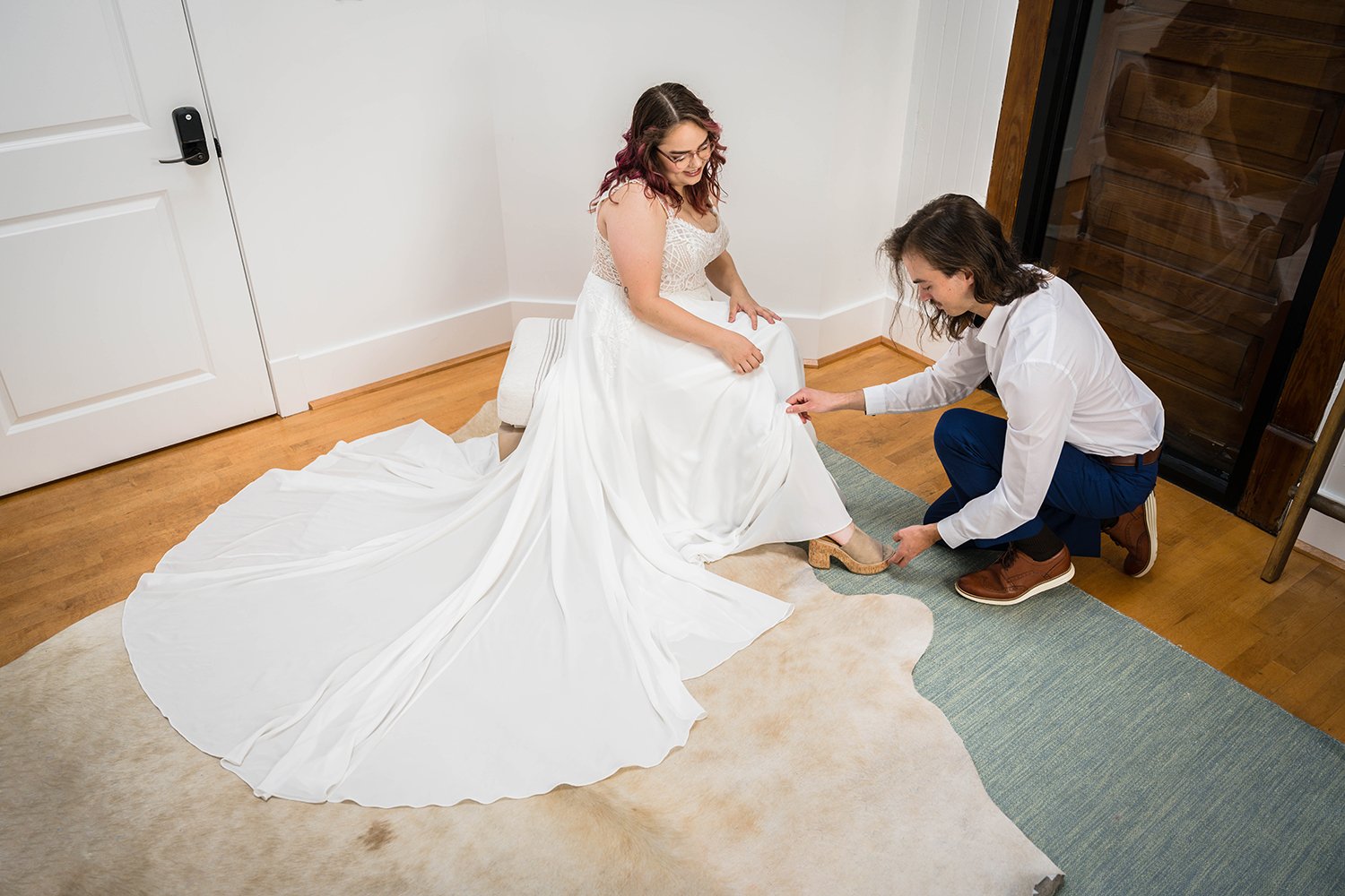 A couple helps one another get ready in their hotel at Fire Station One in Downtown Roanoke for their elopement day.