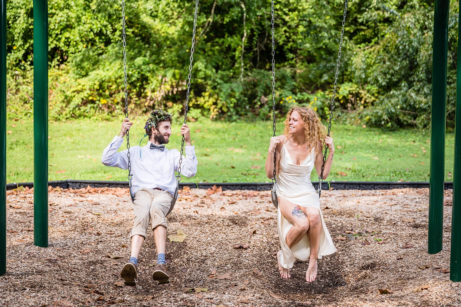 A couple swings together in a playground at Fishburn Park during their elopement.