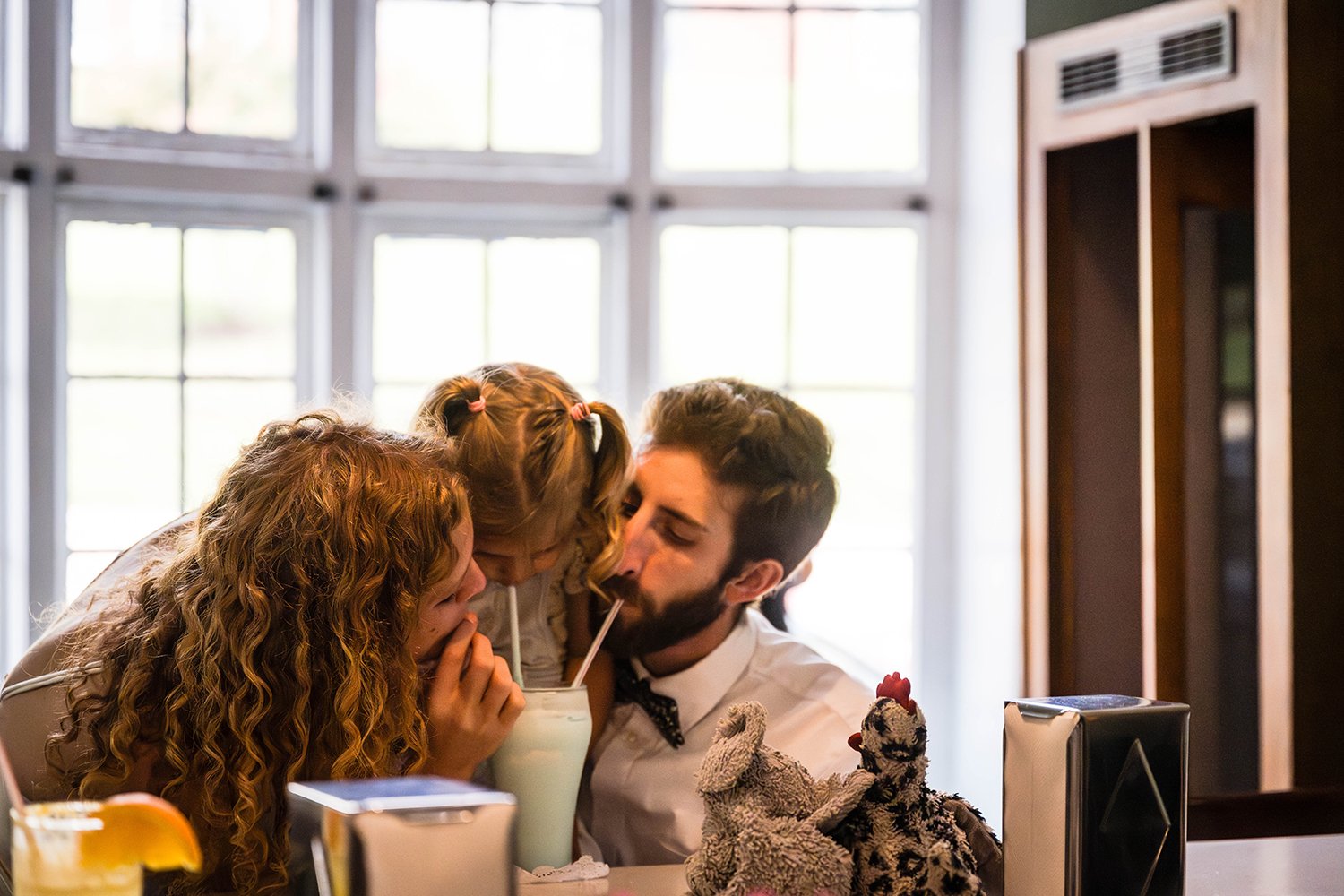 A family of three sip their straws and enjoy a Cotton Candy milkshake at Pop's Ice Cream &amp; Soda Bar in Grandin Village in Roanoke, Virginia.