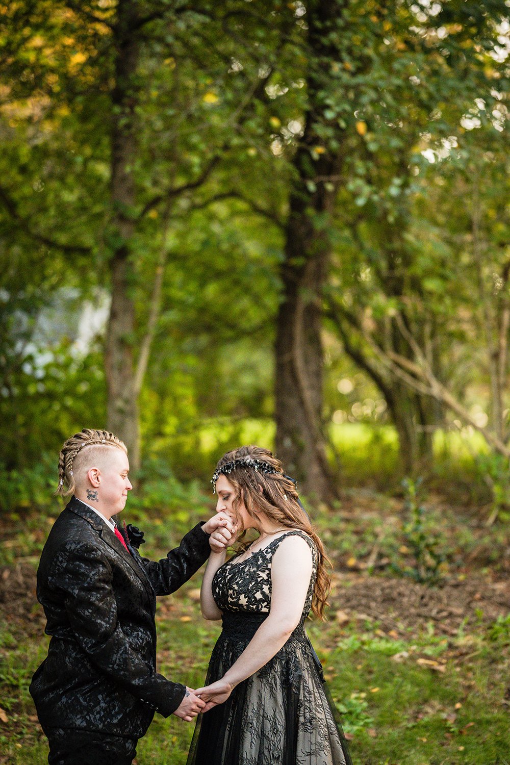 An LGBTQ+ marrier holds the hands of her partner and kisses one of their hands outside of their Roanoke Airbnb on their elopement day.