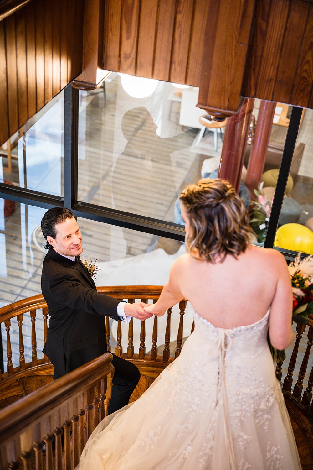 Two marriers reach for one another on a stairwell inside of the Fire Station One Boutique Hotel during their first look on their elopement day.