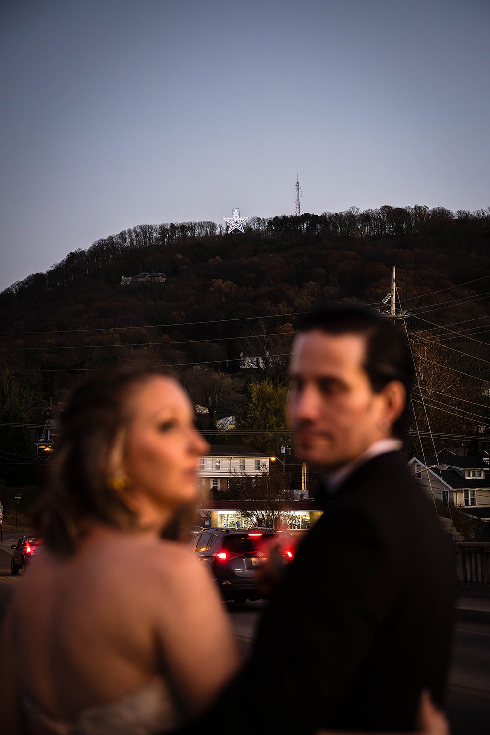  A blurred out couple embrace and look in opposite directions as the Mill Mountain Star illuminates the sky in Roanoke, Virginia. 