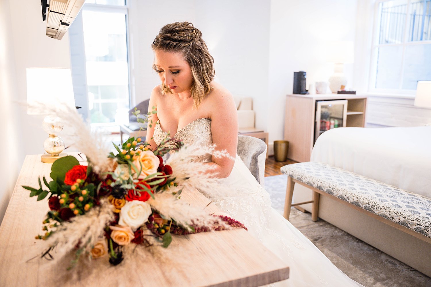 A marrier sits at a desk and writes her vows in a hotel room at Fire Station One.