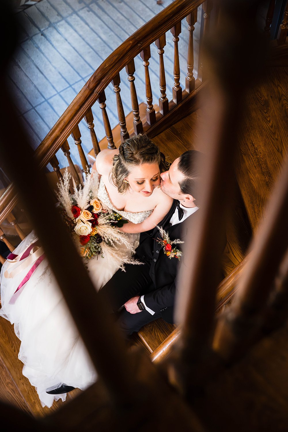 A marrier kisses their partner’s cheek while sitting in a stairwell at the Fire Station One Hotel located in Downtown Roanoke on their elopement day.