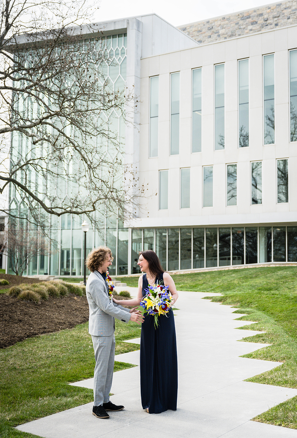 A bride and groom react warmly and happily during their first look on their elopement day outside of the Moss Arts Center.