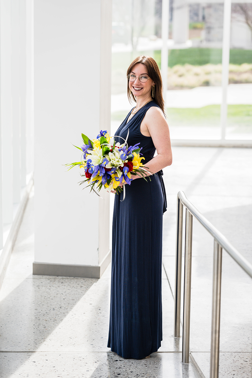 A marrier poses with her wedding bouquet on her elopement day at the Moss Arts Center in Blacksburg, Virginia.