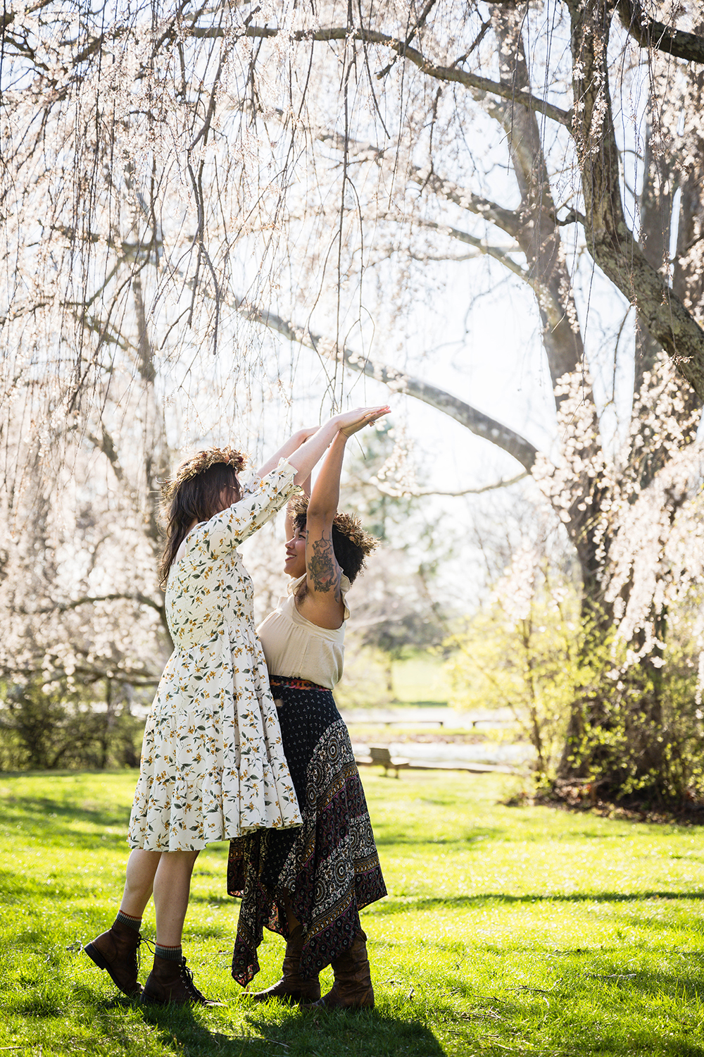 A queer couple dances under a canopy of willow trees at Duck Pond.