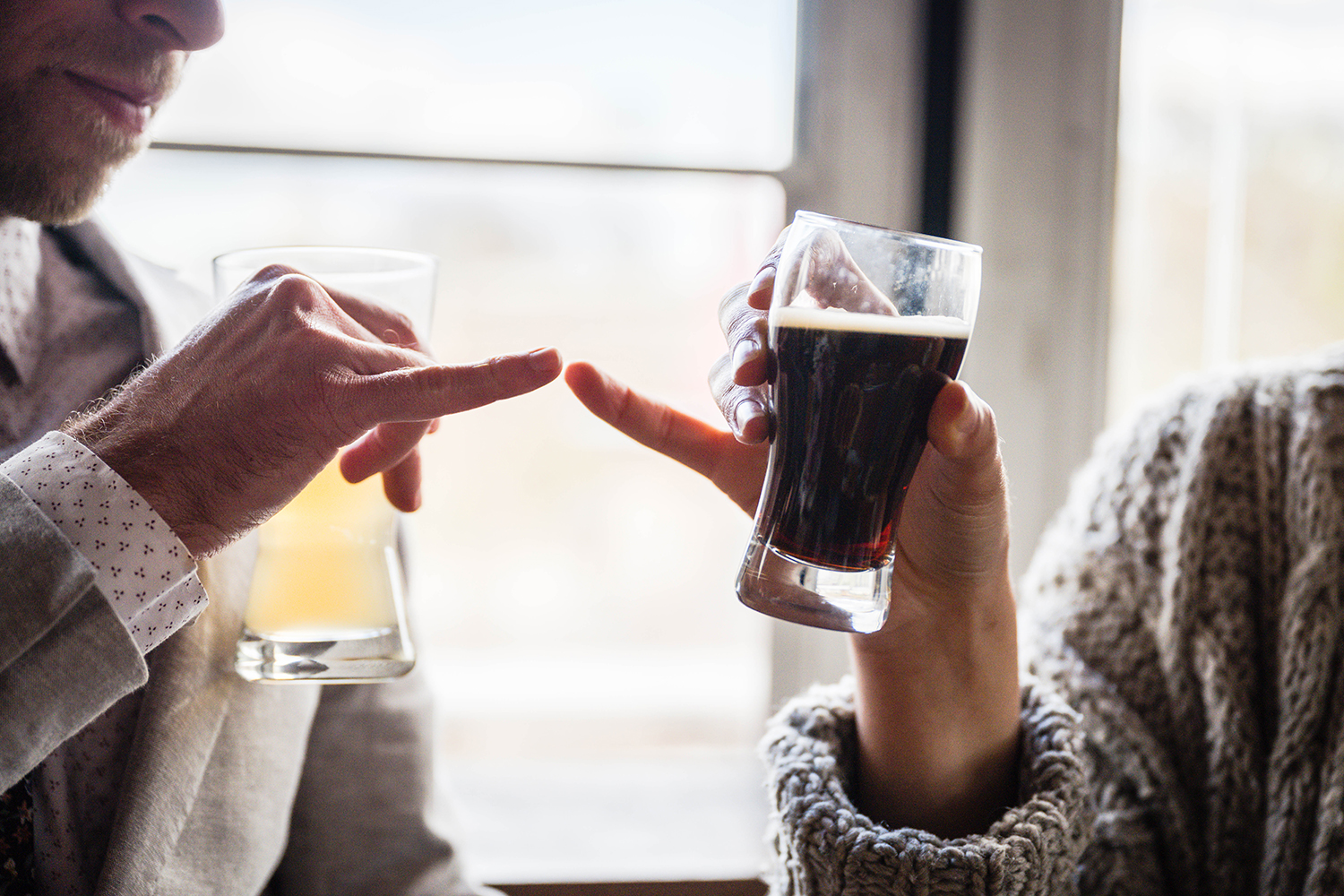 A couple does a special "cheers" handshake at Rising Silo Brewery in Blacksburg, Virginia.