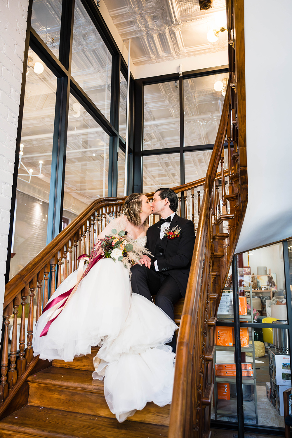 A couple on their elopement day kiss while sitting on an antique stairwell featured in the Fire Station One Hotel in Roanoke, Virginia.
