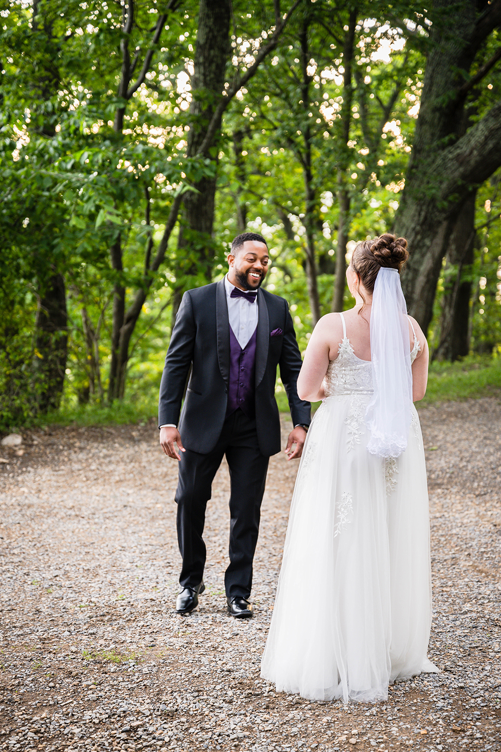 A groom turns around to see his bride in her wedding dress for the first time and smiles widely during their first look at Mill Mountain Park in Roanoke, Virginia on their elopement day.