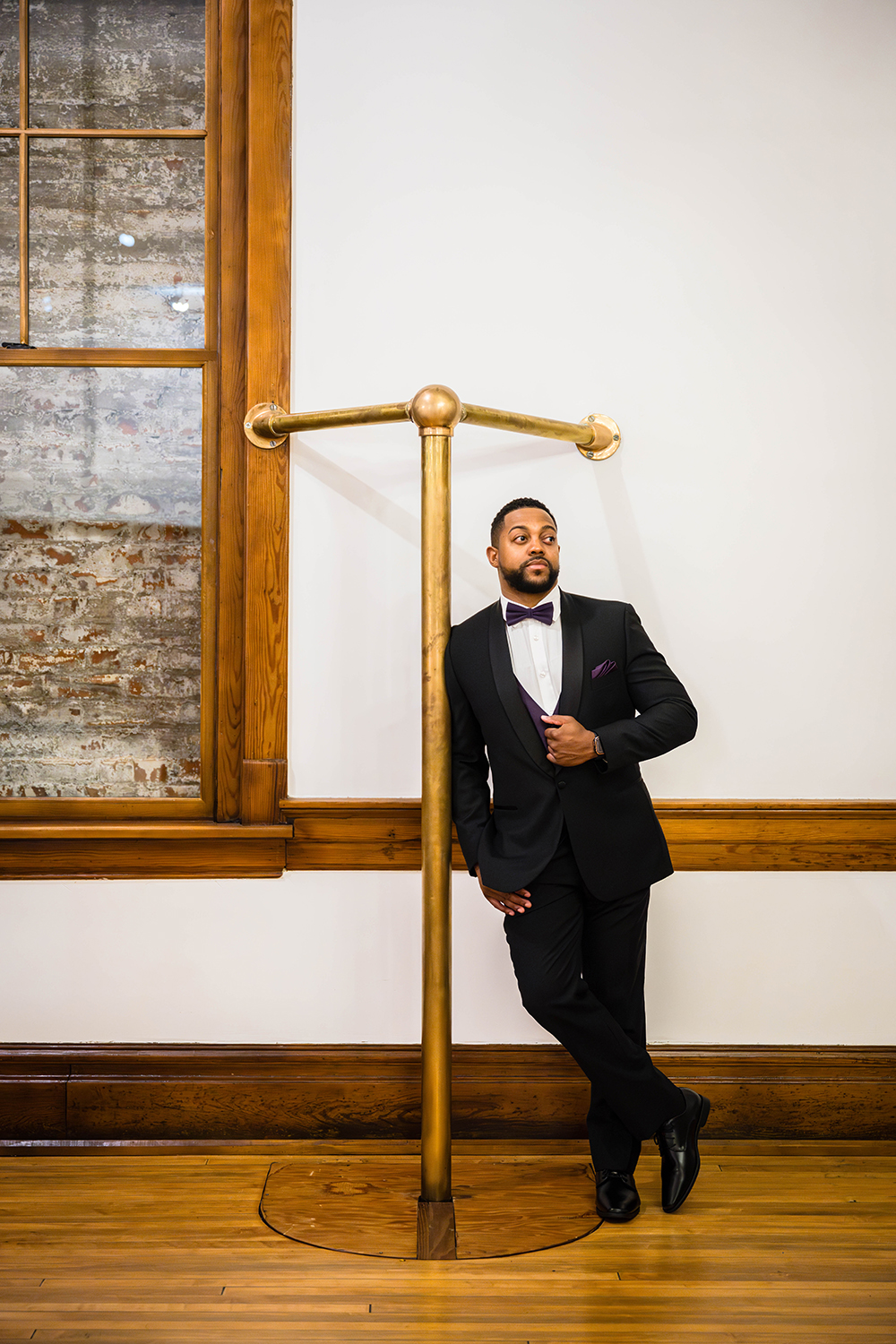 A person wearing their wedding attire stands and poses against a fire station pole at Fire Station One Boutique Hotel in Roanoke, Virginia.