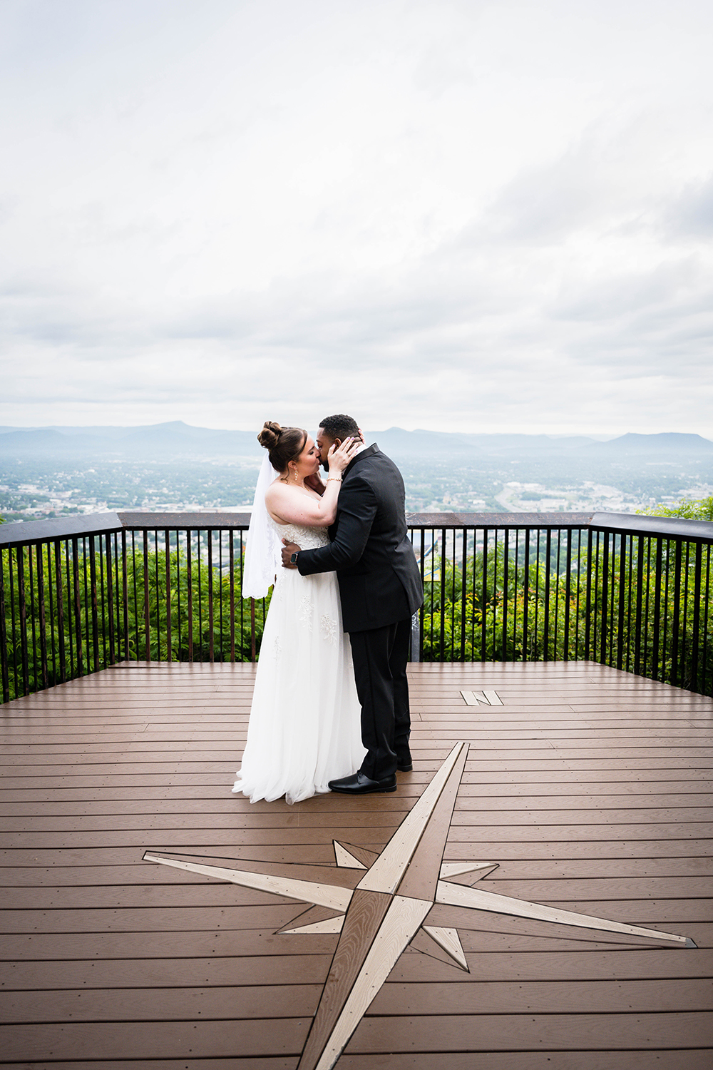 A couple embraces and kisses after they're pronounced husband and wife during their wedding ceremony at Mill Mountain Park at the Mill Mountain Star Overlook in Roanoke, Virginia.