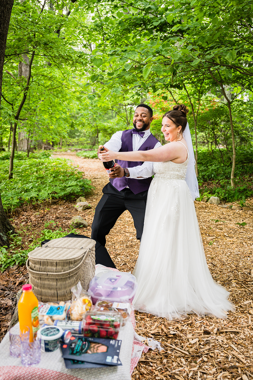 A couple prepares to pop a bottle of champagne as they prepare for their breakfast picnic at the Mill Mountain Wildflower Garden in Roanoke, Virginia.