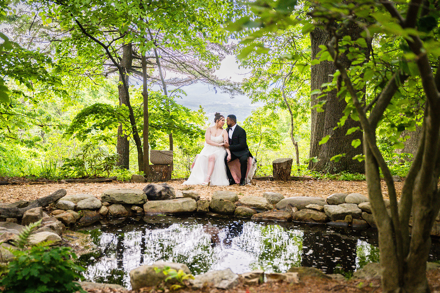 A couple on their elopement day sit on a bench and look into each other's eyes before eating their breakfast picnic at the Mill Mountain Wildflower Garden in Roanoke, Virginia.