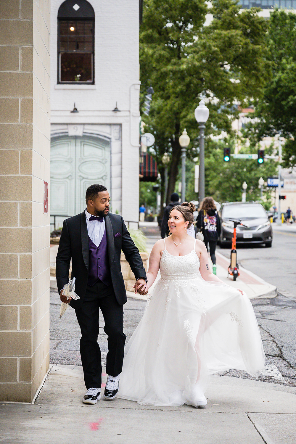 A couple walk hand-in-hand and look at one another as they walk through Downtown Roanoke on their elopement day.