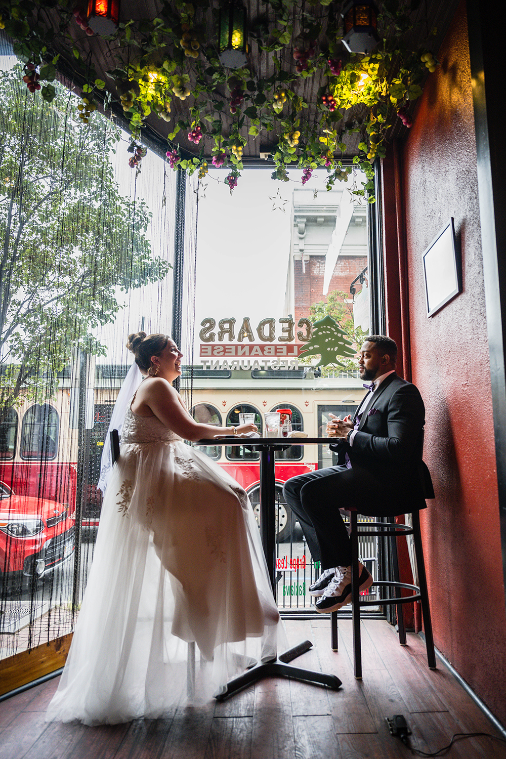 A couple sits at a high top table inside of Cedar's Lebanese Restaurant in Downtown Roanoke. The pair appear to smile as the Star City line bus passes outside.