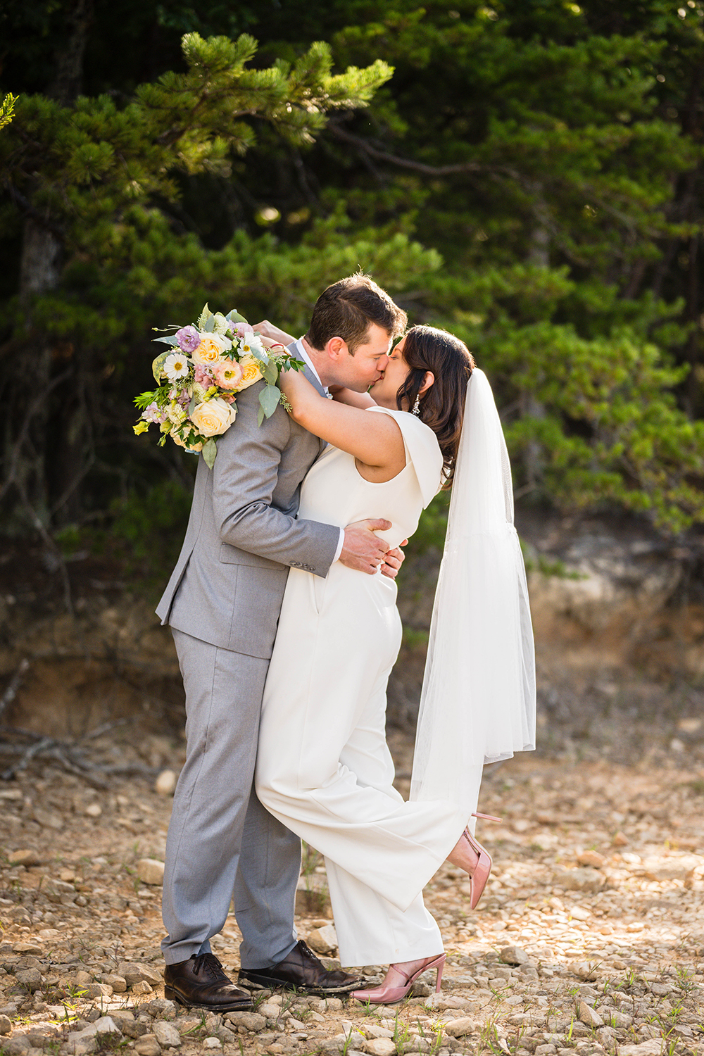 A couple goes in for a kiss after their first look on the shores of Carvin's Cove.