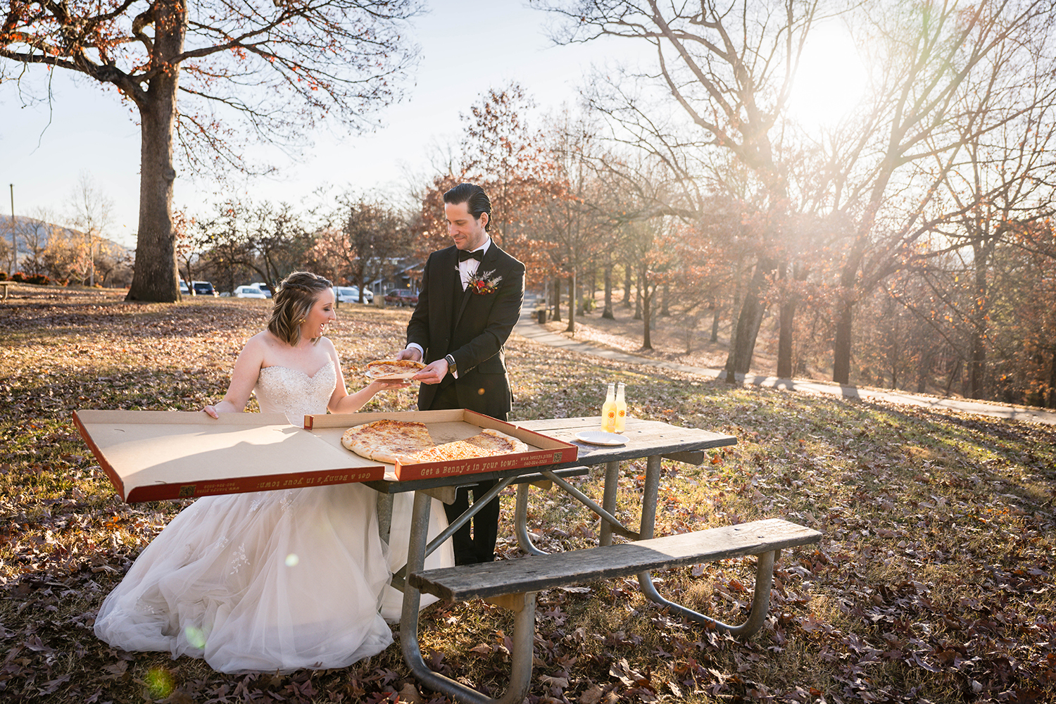 A groom feeds his bride a big slice of Benny's pizza at Mill Mountain park in Roanoke, Virginia on their intimate wedding day.